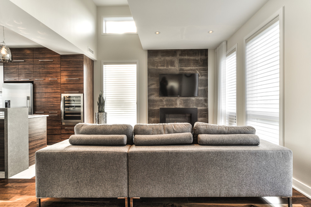 Mittelgroßes, Offenes Modernes Wohnzimmer mit Hängekamin, Kaminumrandung aus Stein und TV-Wand in Montreal