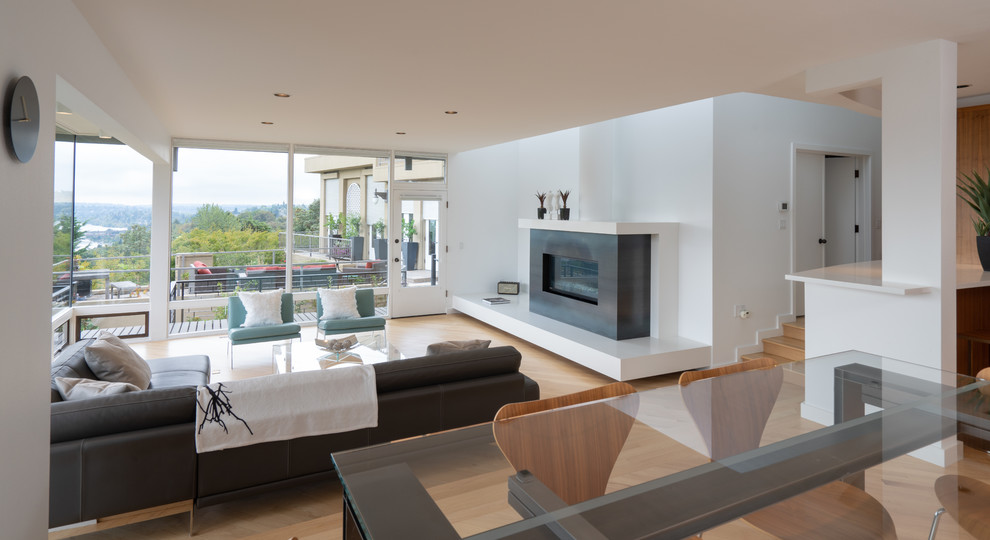 Photo of a modern open plan living room in Seattle with white walls and light hardwood flooring.