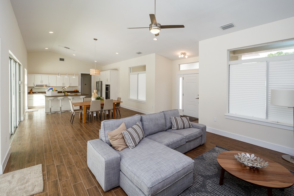 Foto di un soggiorno chic di medie dimensioni e aperto con pareti beige, pavimento in gres porcellanato, nessuna TV e pavimento marrone
