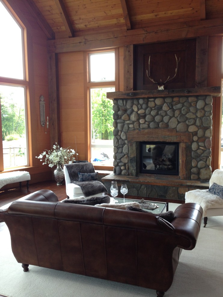 Example of a large country formal and loft-style dark wood floor living room design in Portland with white walls, a standard fireplace, a stone fireplace and a corner tv