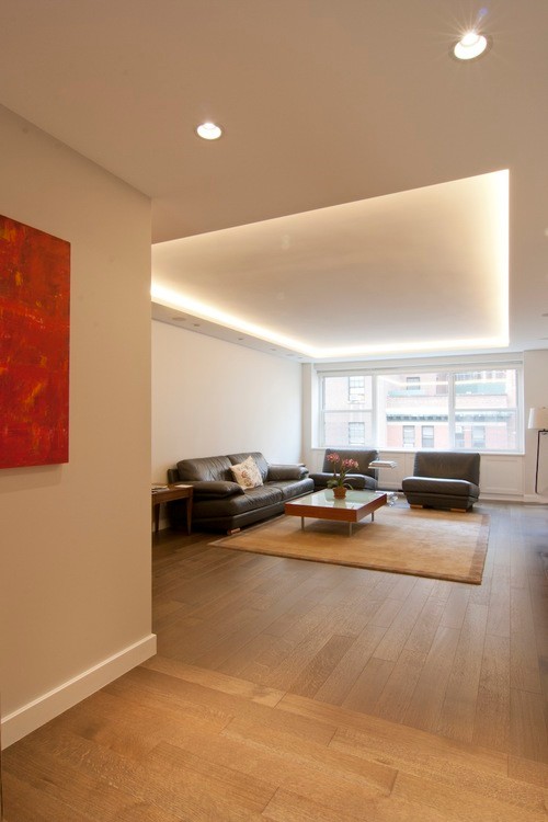 Diseño de salón abierto contemporáneo de tamaño medio con paredes blancas, suelo de madera clara y suelo beige