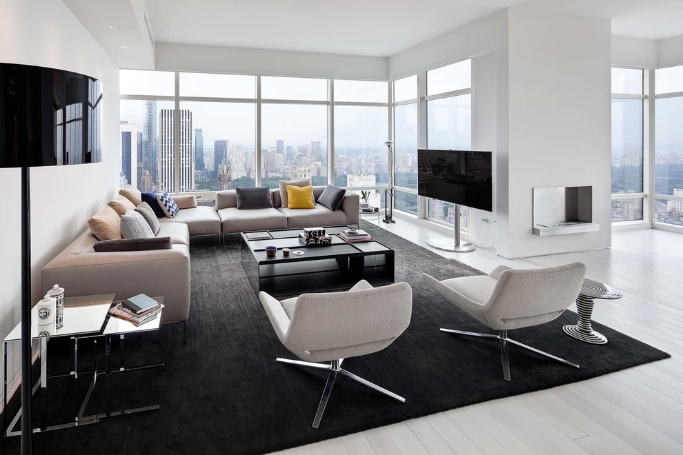 Example of a trendy open concept white floor living room design in New York with white walls and a tv stand