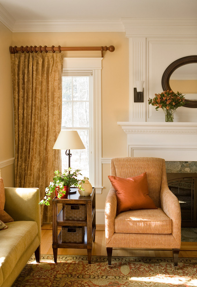 Aménagement d'un grand salon classique fermé avec un mur beige, un sol en bois brun, une cheminée standard et un manteau de cheminée en pierre.
