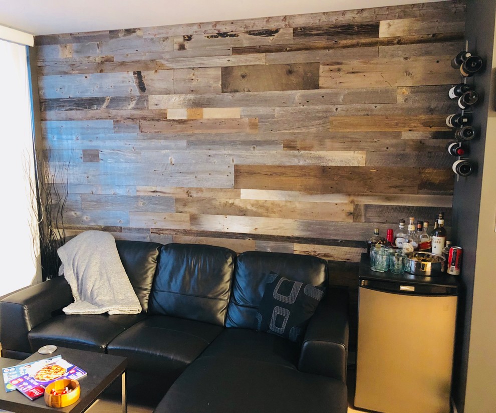 Diseño de salón con barra de bar cerrado industrial pequeño con paredes marrones, suelo laminado, pared multimedia y suelo beige