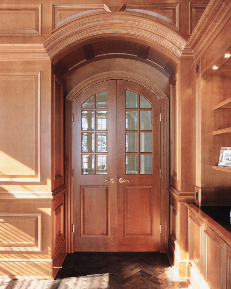 Foto de biblioteca en casa cerrada tradicional grande con suelo de madera en tonos medios, todas las chimeneas, marco de chimenea de madera y televisor retractable