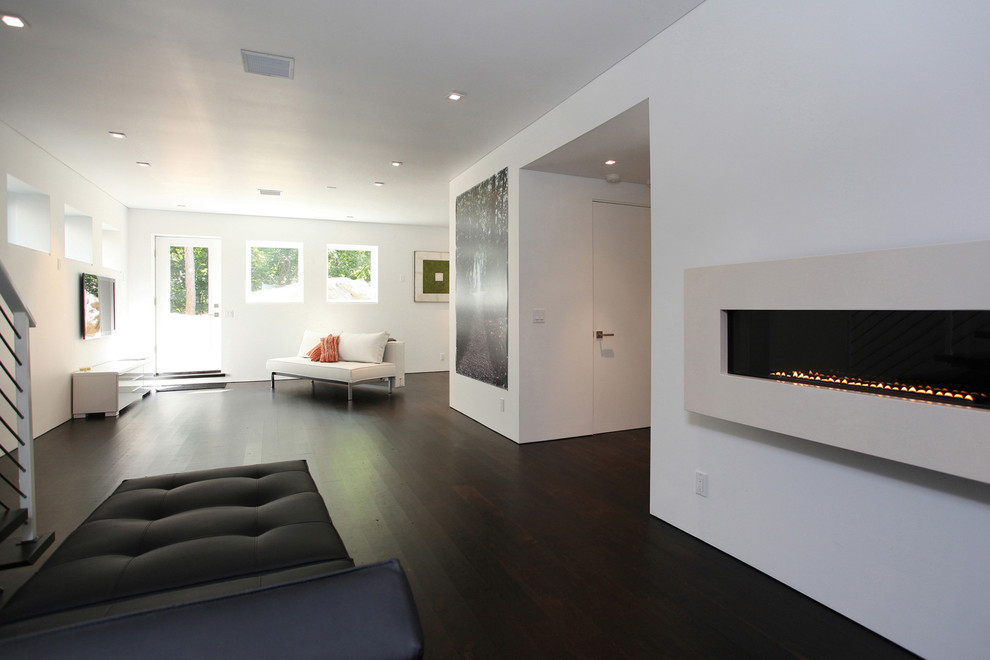 Стильный дизайн: парадная, открытая гостиная комната в современном стиле с белыми стенами, темным паркетным полом, горизонтальным камином и фасадом камина из камня без телевизора - последний тренд