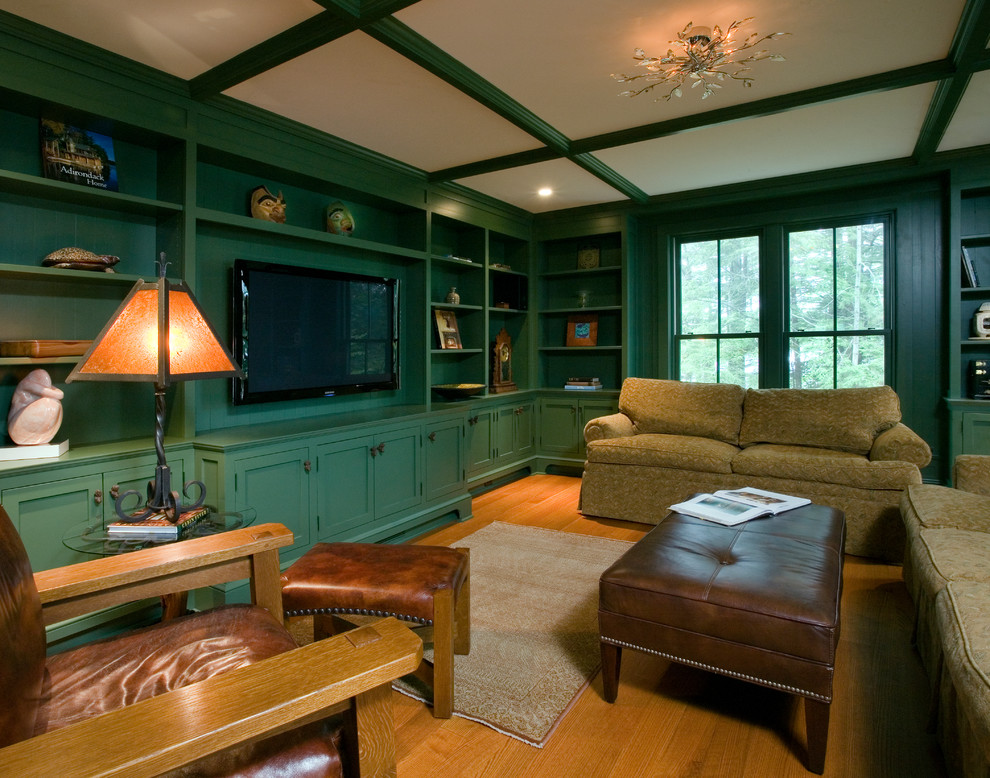 На фото: большая гостиная комната в стиле рустика с с книжными шкафами и полками, зелеными стенами, светлым паркетным полом и телевизором на стене без камина