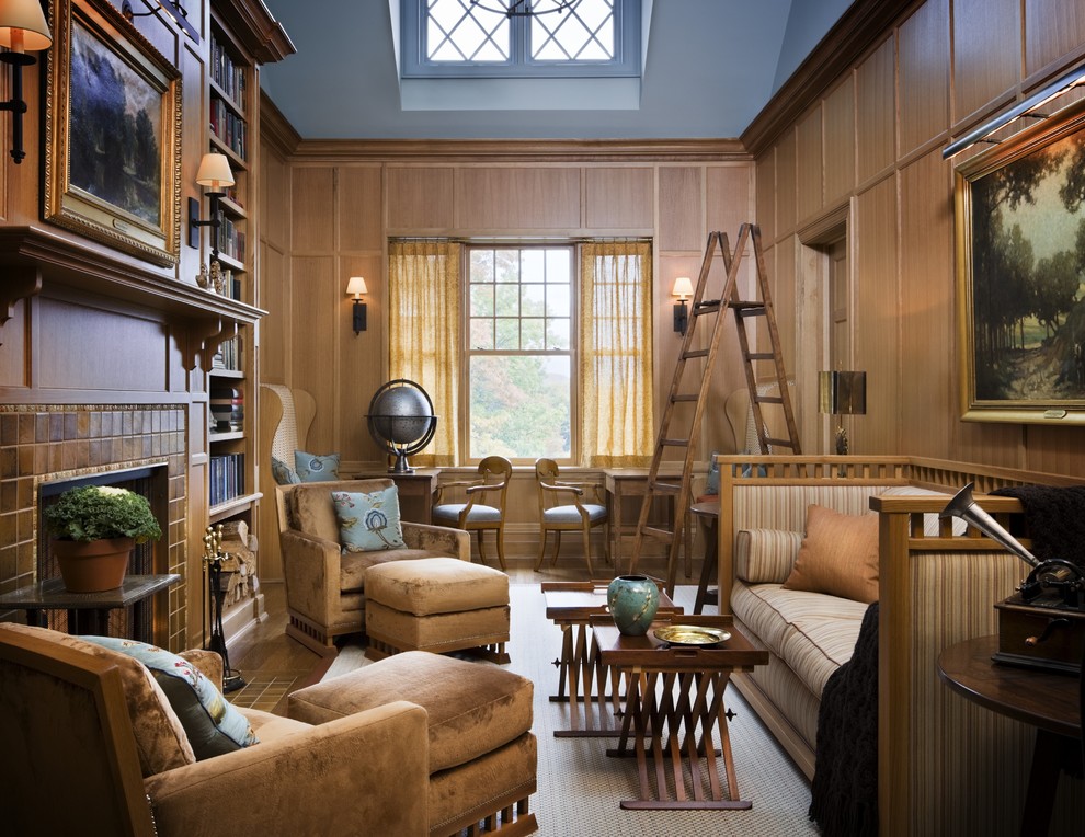 Inredning av ett klassiskt mycket stort vardagsrum, med ett bibliotek, bruna väggar, ljust trägolv, en standard öppen spis och en spiselkrans i trä