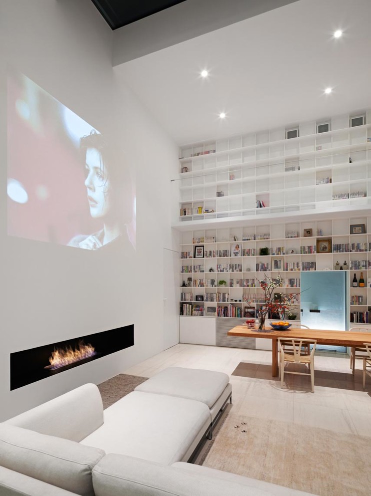 Inredning av ett modernt allrum med öppen planlösning, med vita väggar, en bred öppen spis, en dold TV och beiget golv