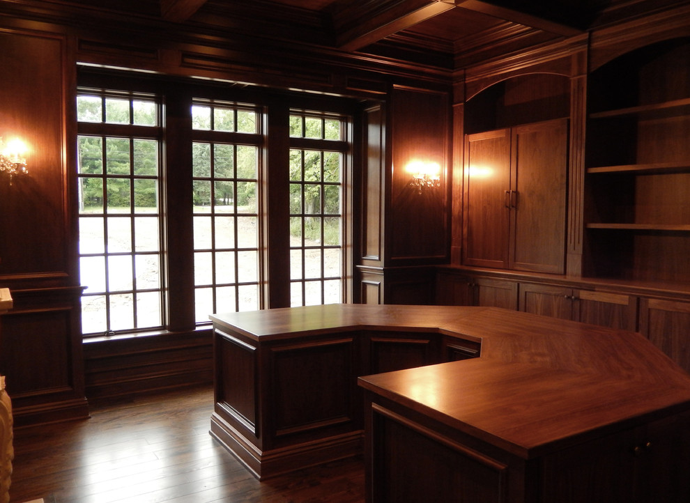 Ejemplo de biblioteca en casa cerrada tradicional sin televisor con paredes marrones y suelo de madera oscura