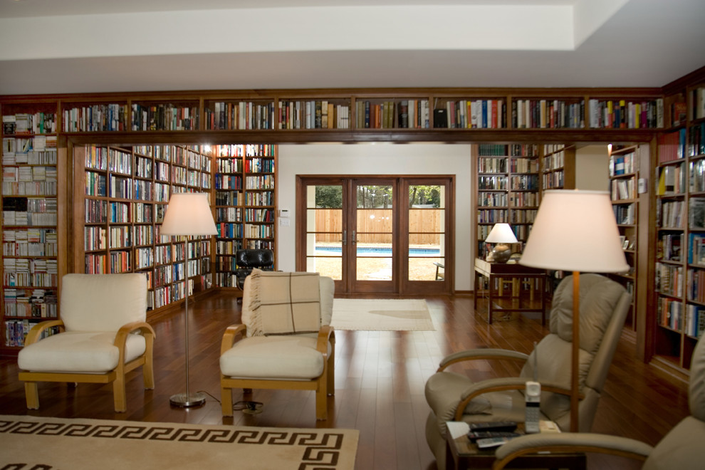 Inspiration för mellanstora klassiska allrum med öppen planlösning, med ett bibliotek, vita väggar, mörkt trägolv och en fristående TV