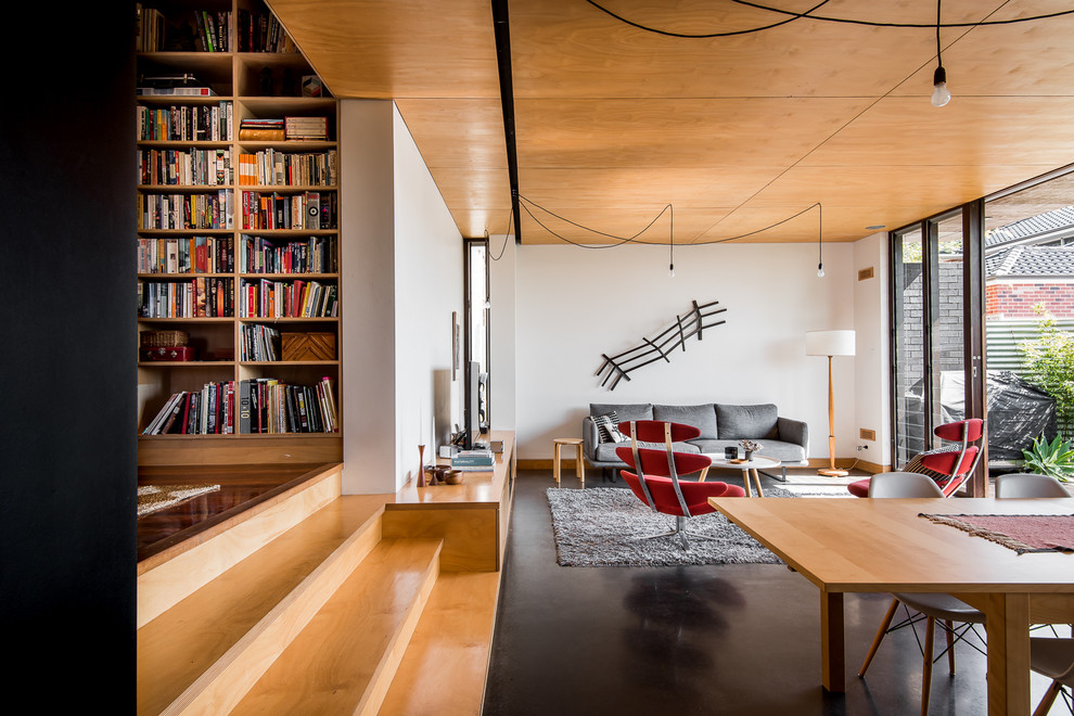 Ejemplo de biblioteca en casa abierta nórdica de tamaño medio con paredes blancas, suelo de madera clara y televisor independiente