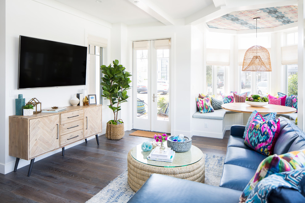 Medium sized beach style enclosed living room in Orange County with white walls, medium hardwood flooring, a wall mounted tv and brown floors.