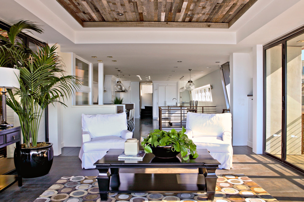 This is an example of a large contemporary open plan living room in Los Angeles with concrete flooring and white walls.
