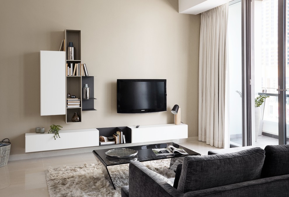 Ejemplo de salón cerrado actual pequeño con paredes beige, suelo de madera clara y televisor colgado en la pared