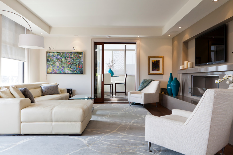 Esempio di un grande soggiorno design aperto con sala formale, pareti beige, parquet scuro, camino classico e TV a parete