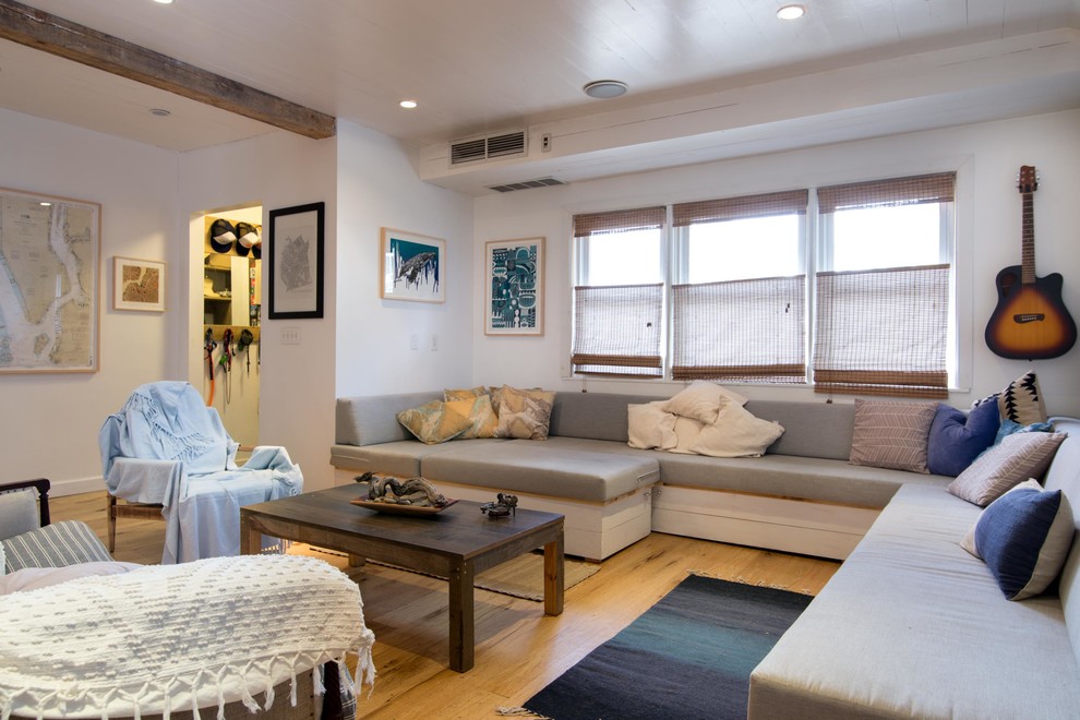 Imagen de salón abierto marinero de tamaño medio sin chimenea y televisor con paredes blancas y suelo de madera clara