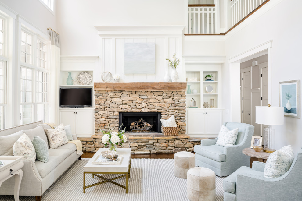 Inspiration for a transitional open concept medium tone wood floor and brown floor living room remodel in Orlando with white walls, a standard fireplace, a stone fireplace and a wall-mounted tv