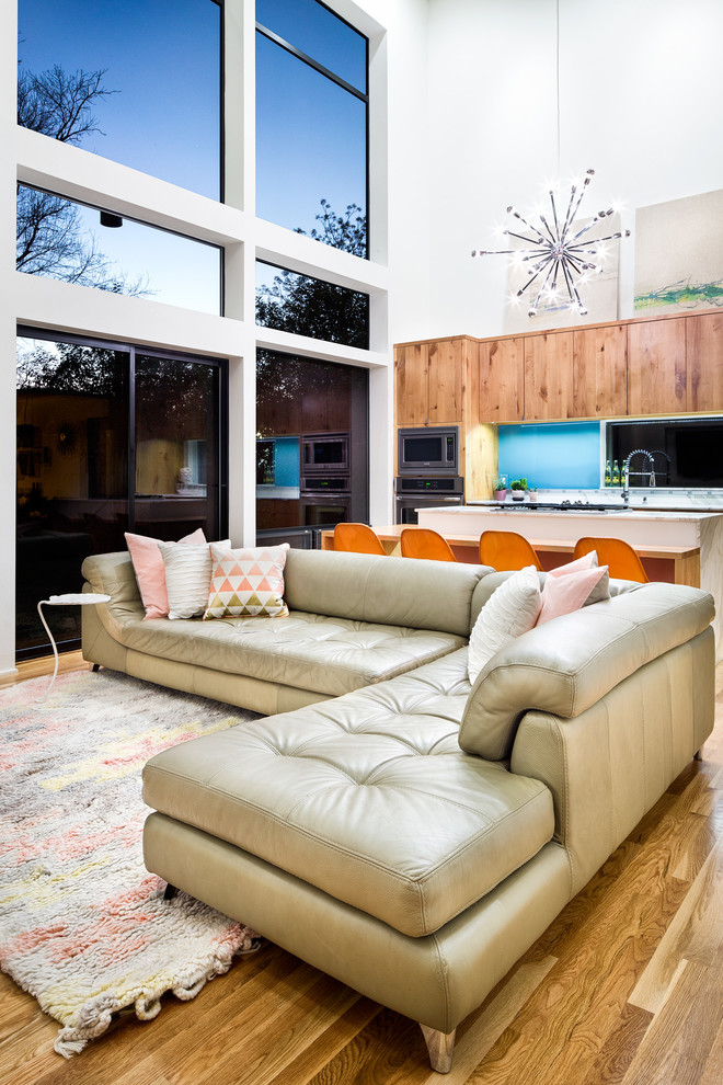 Mittelgroßes, Offenes Modernes Wohnzimmer mit weißer Wandfarbe, braunem Holzboden und TV-Wand in Austin