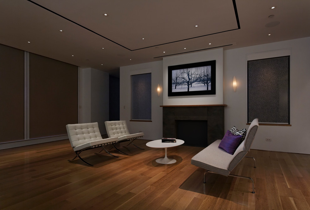 Photo of a large modern formal open plan living room in Toronto with no tv, white walls, medium hardwood flooring, a standard fireplace, a tiled fireplace surround and brown floors.