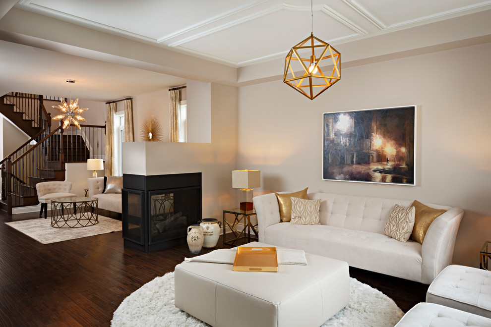 Cette photo montre un salon tendance ouvert avec un mur beige, parquet foncé, une cheminée double-face et un manteau de cheminée en métal.