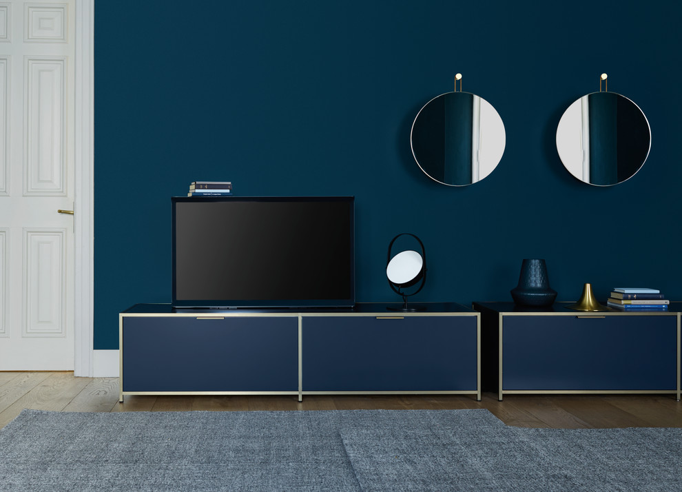 Cette image montre un salon minimaliste de taille moyenne et ouvert avec une salle de réception, un mur bleu, un sol en bois brun, aucune cheminée, un téléviseur indépendant et un sol marron.