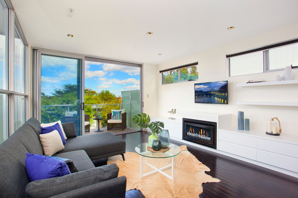 Mittelgroßes, Offenes Modernes Wohnzimmer mit weißer Wandfarbe, dunklem Holzboden, Kamin und TV-Wand in Sydney