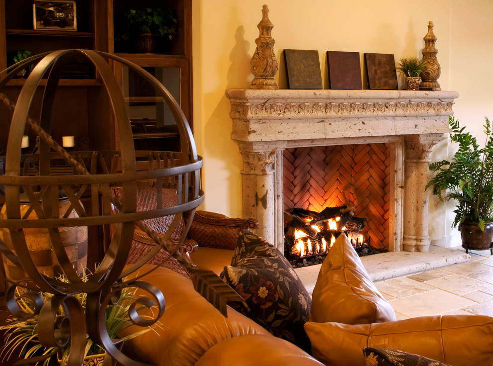 Example of a tuscan living room design in Dallas with a standard fireplace and a stone fireplace
