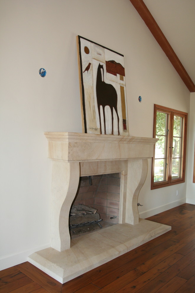 Aménagement d'un salon classique de taille moyenne et ouvert avec un mur blanc, un sol en bois brun, une cheminée standard et un manteau de cheminée en pierre.