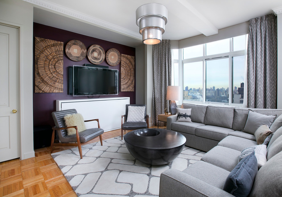 Источник вдохновения для домашнего уюта: большая открытая гостиная комната в современном стиле с серыми стенами, телевизором на стене и светлым паркетным полом