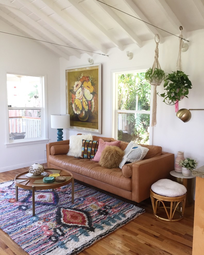 Eclectic medium tone wood floor and brown floor living room photo in Los Angeles with white walls