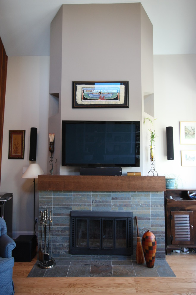 Imagen de salón cerrado contemporáneo de tamaño medio con paredes beige, suelo de madera clara, todas las chimeneas, marco de chimenea de baldosas y/o azulejos y televisor colgado en la pared