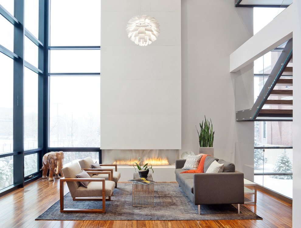 Modernes Wohnzimmer mit weißer Wandfarbe, braunem Holzboden und Gaskamin in Chicago