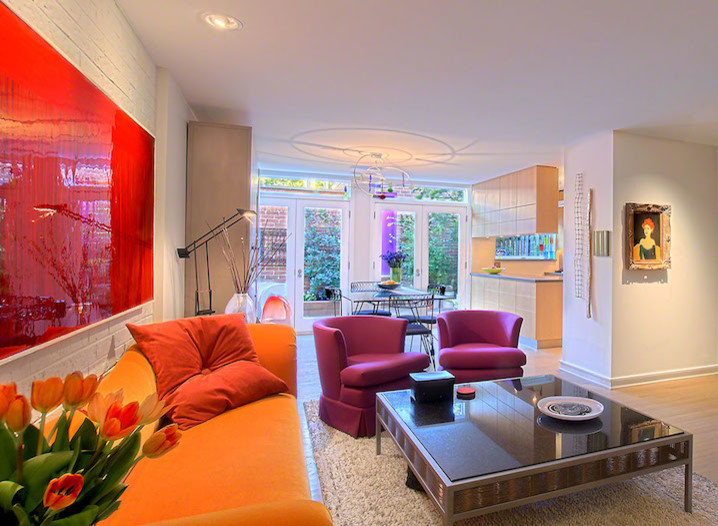 На фото: большая открытая гостиная комната в современном стиле с белыми стенами, светлым паркетным полом, угловым камином, фасадом камина из кирпича и скрытым телевизором