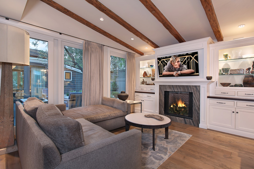 Immagine di un soggiorno classico con parquet chiaro e TV a parete