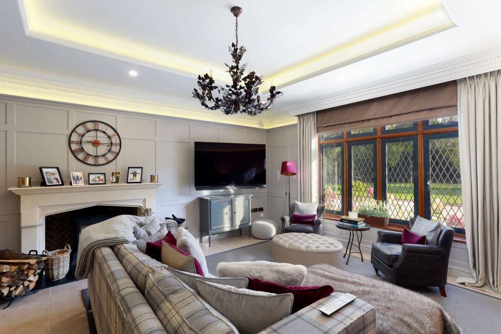 Idee per un grande soggiorno classico aperto con pareti grigie, camino classico, cornice del camino in intonaco, TV a parete e pavimento beige
