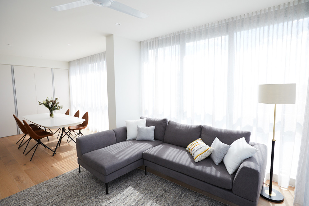Esempio di un soggiorno minimalista aperto con pareti bianche e parquet chiaro
