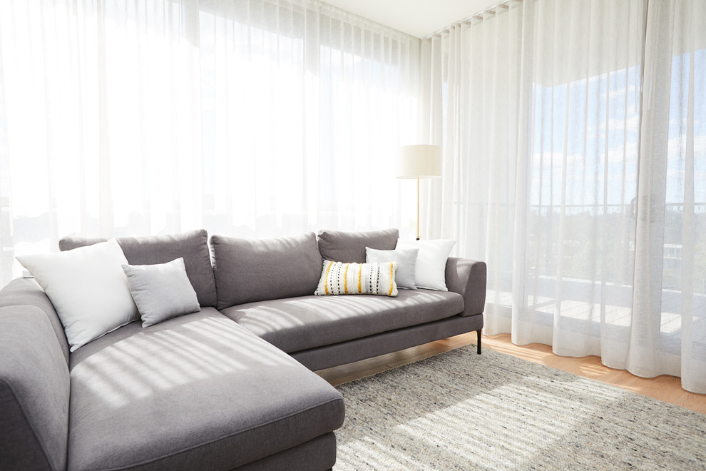 Immagine di un soggiorno moderno aperto con pareti bianche e parquet chiaro
