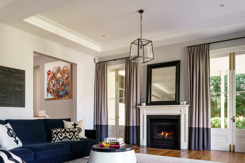 シドニーにあるラグジュアリーな広いトラディショナルスタイルのおしゃれな独立型リビング (青い壁、無垢フローリング、標準型暖炉、木材の暖炉まわり、茶色い床) の写真