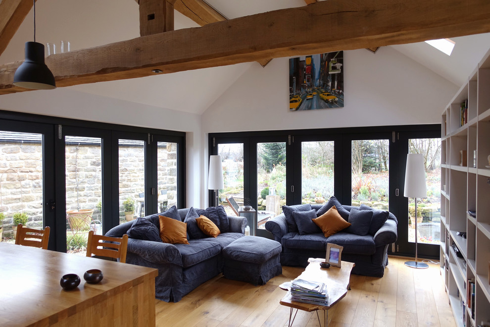 Imagen de salón abierto de estilo de casa de campo pequeño con paredes blancas y suelo de madera en tonos medios