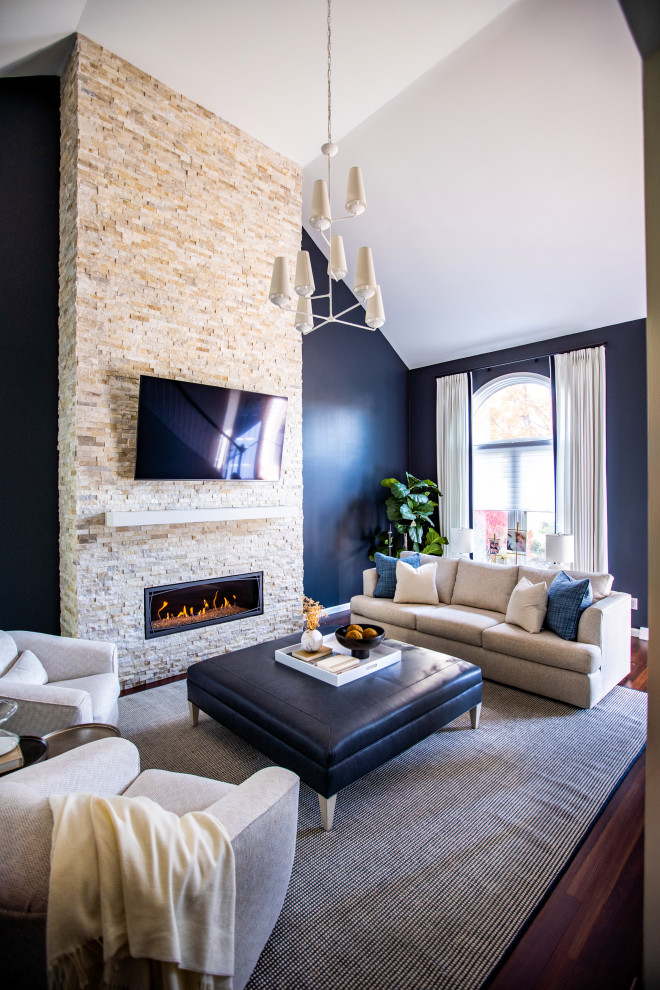 Идея дизайна: открытая гостиная комната в стиле неоклассика (современная классика) с синими стенами, темным паркетным полом, горизонтальным камином, фасадом камина из каменной кладки, телевизором на стене, коричневым полом и сводчатым потолком