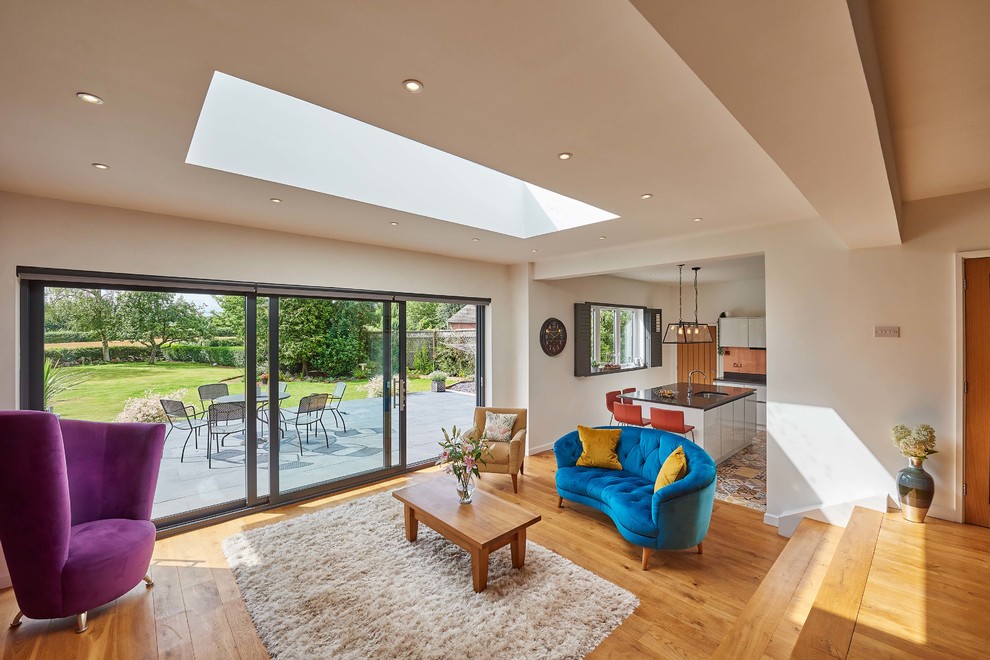 Großes, Offenes Modernes Wohnzimmer ohne Kamin mit braunem Holzboden, TV-Wand und orangem Boden in West Midlands