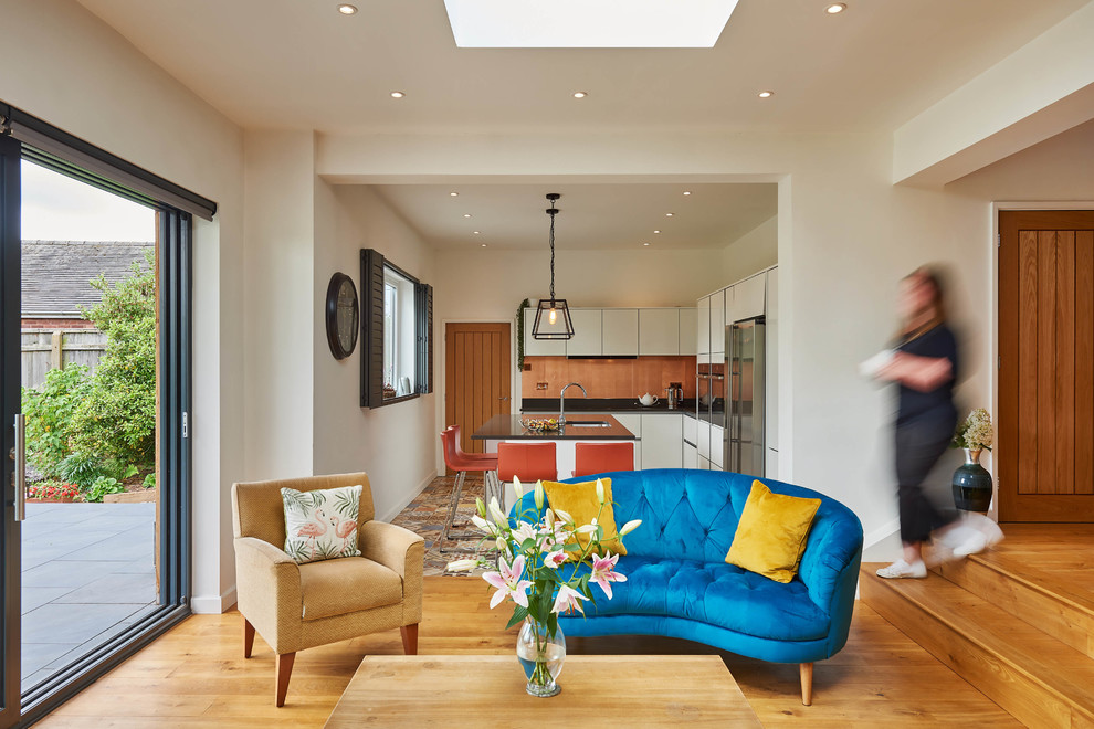 Mittelgroßes, Offenes Modernes Wohnzimmer ohne Kamin mit braunem Holzboden, TV-Wand und orangem Boden in West Midlands