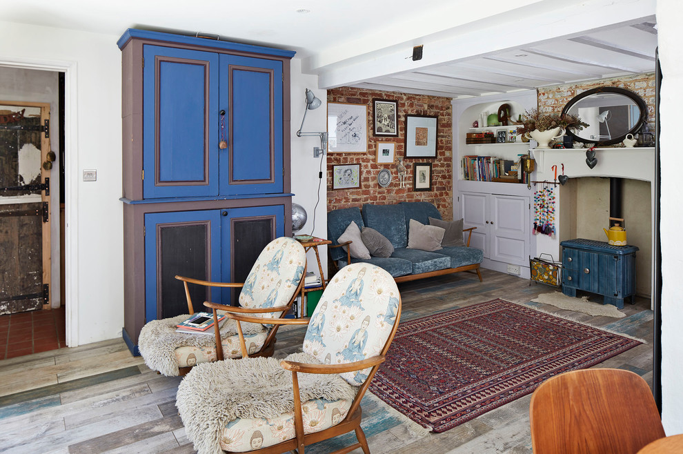 Пример оригинального дизайна: изолированная гостиная комната среднего размера в стиле кантри с печью-буржуйкой, серым полом и деревянным полом