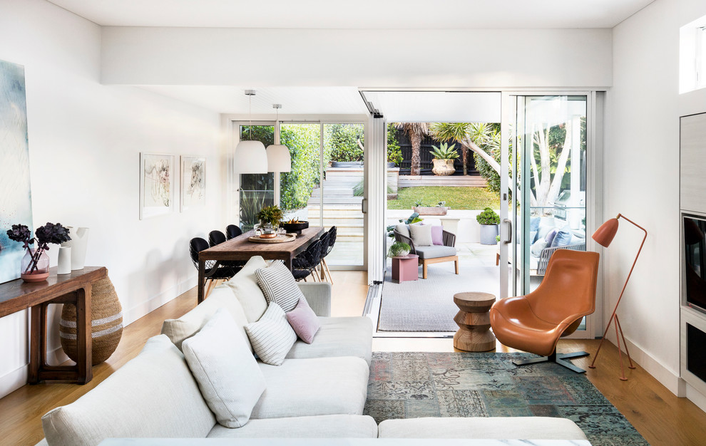 Mittelgroßes, Offenes Modernes Wohnzimmer mit weißer Wandfarbe, hellem Holzboden und Multimediawand in Sydney