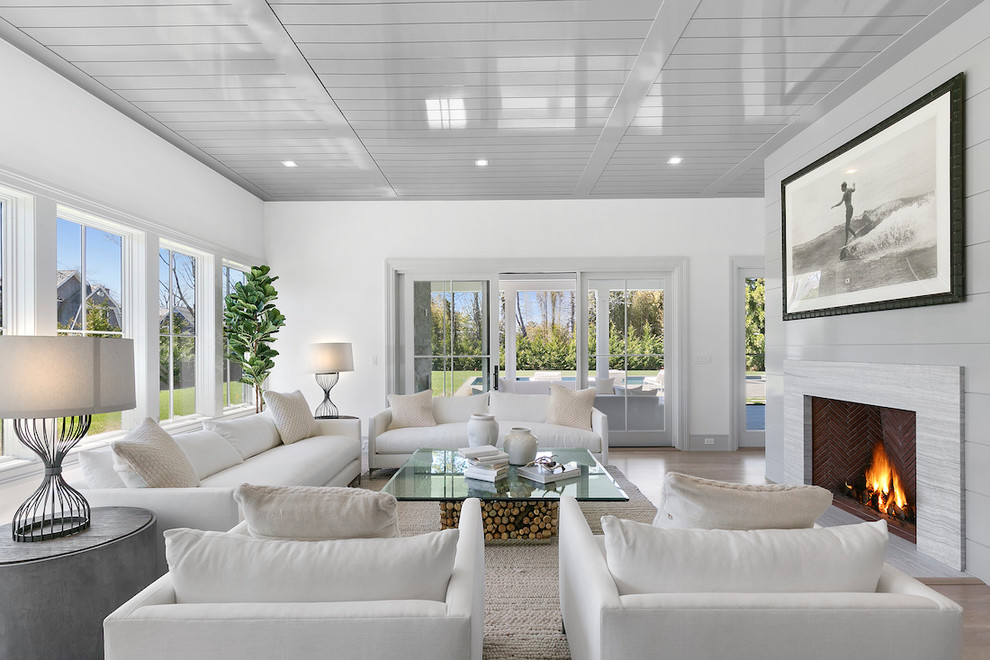Foto di un soggiorno stile marinaro con pareti bianche, parquet chiaro, camino classico e pavimento beige