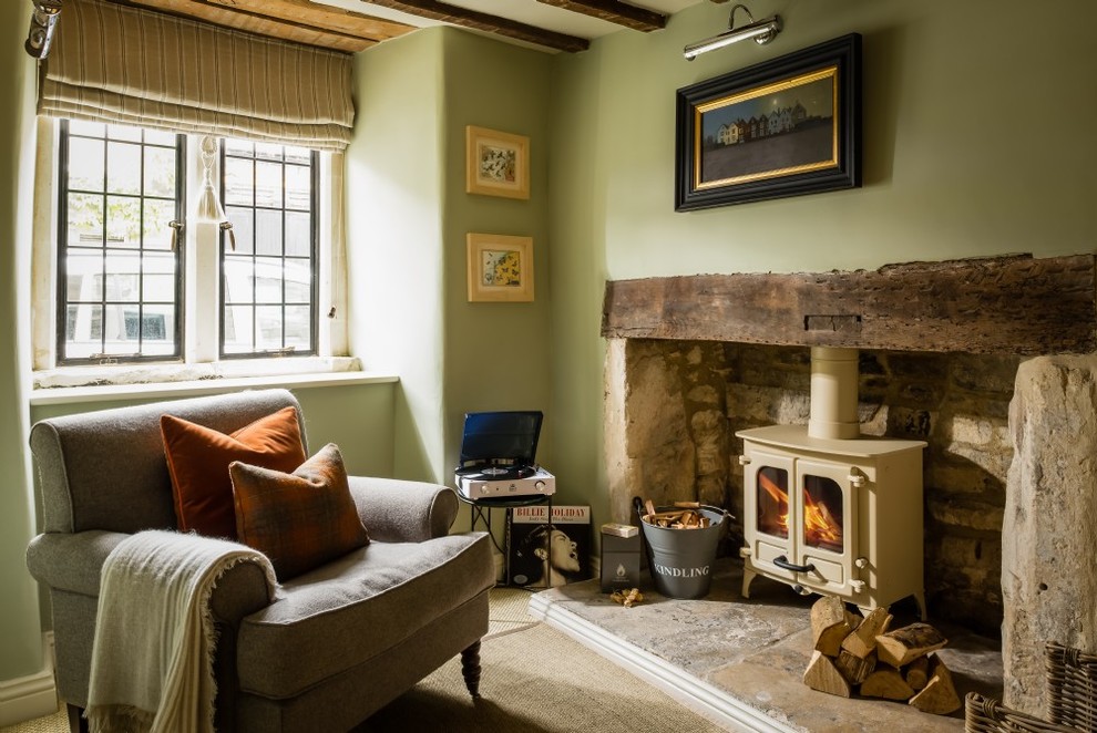 Foto de salón para visitas abierto campestre de tamaño medio con paredes verdes, moqueta, estufa de leña, marco de chimenea de piedra y suelo beige