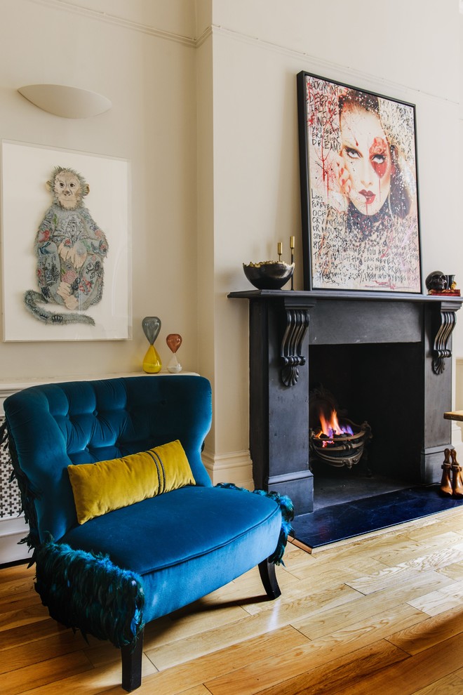 ロンドンにあるヴィクトリアン調のおしゃれな応接間 (淡色無垢フローリング、標準型暖炉、コンクリートの暖炉まわり、ベージュの壁) の写真