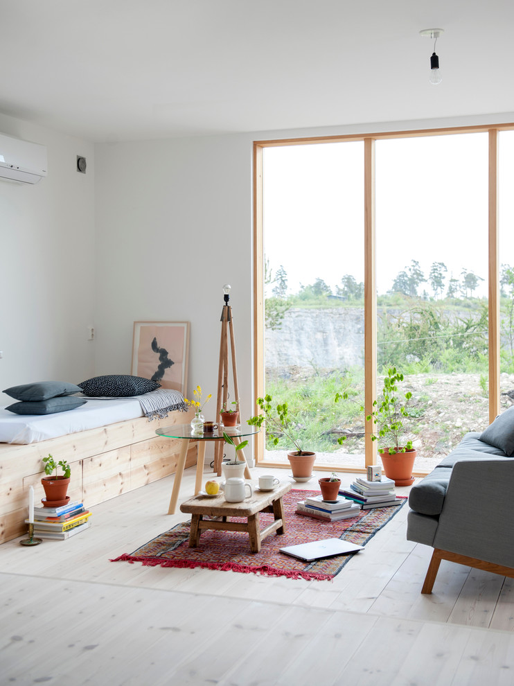 Bild på ett litet minimalistiskt separat vardagsrum, med ett finrum, vita väggar och ljust trägolv
