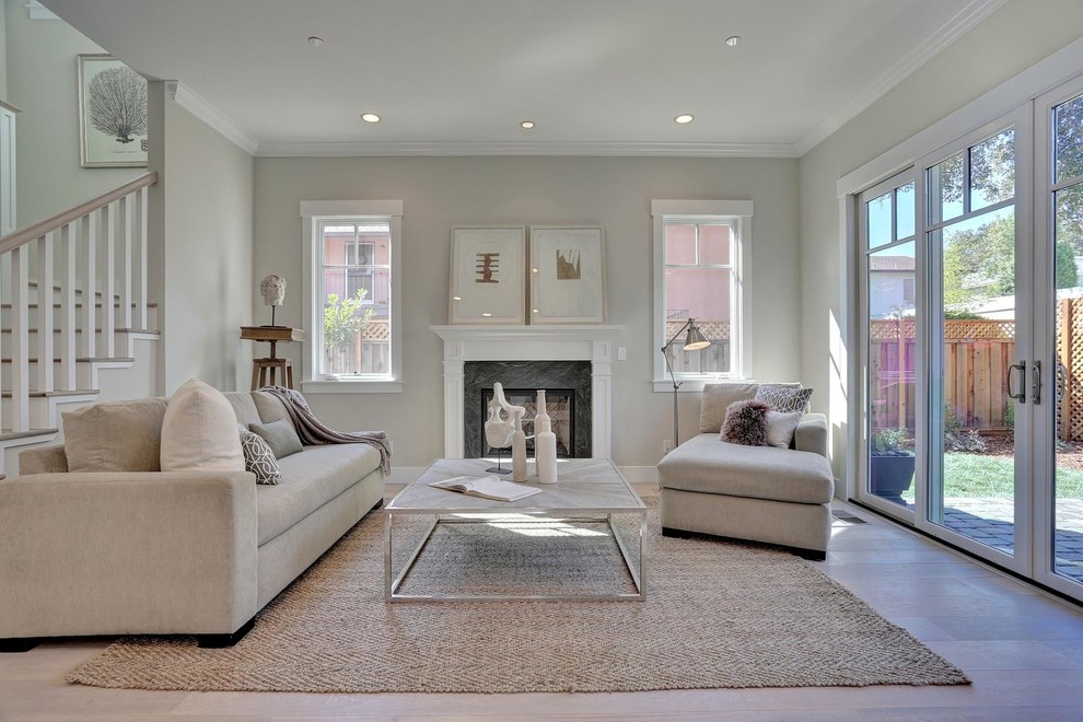 Photo of a medium sized traditional formal open plan living room in San Francisco with a standard fireplace, a stone fireplace surround, light hardwood flooring, grey walls and no tv.